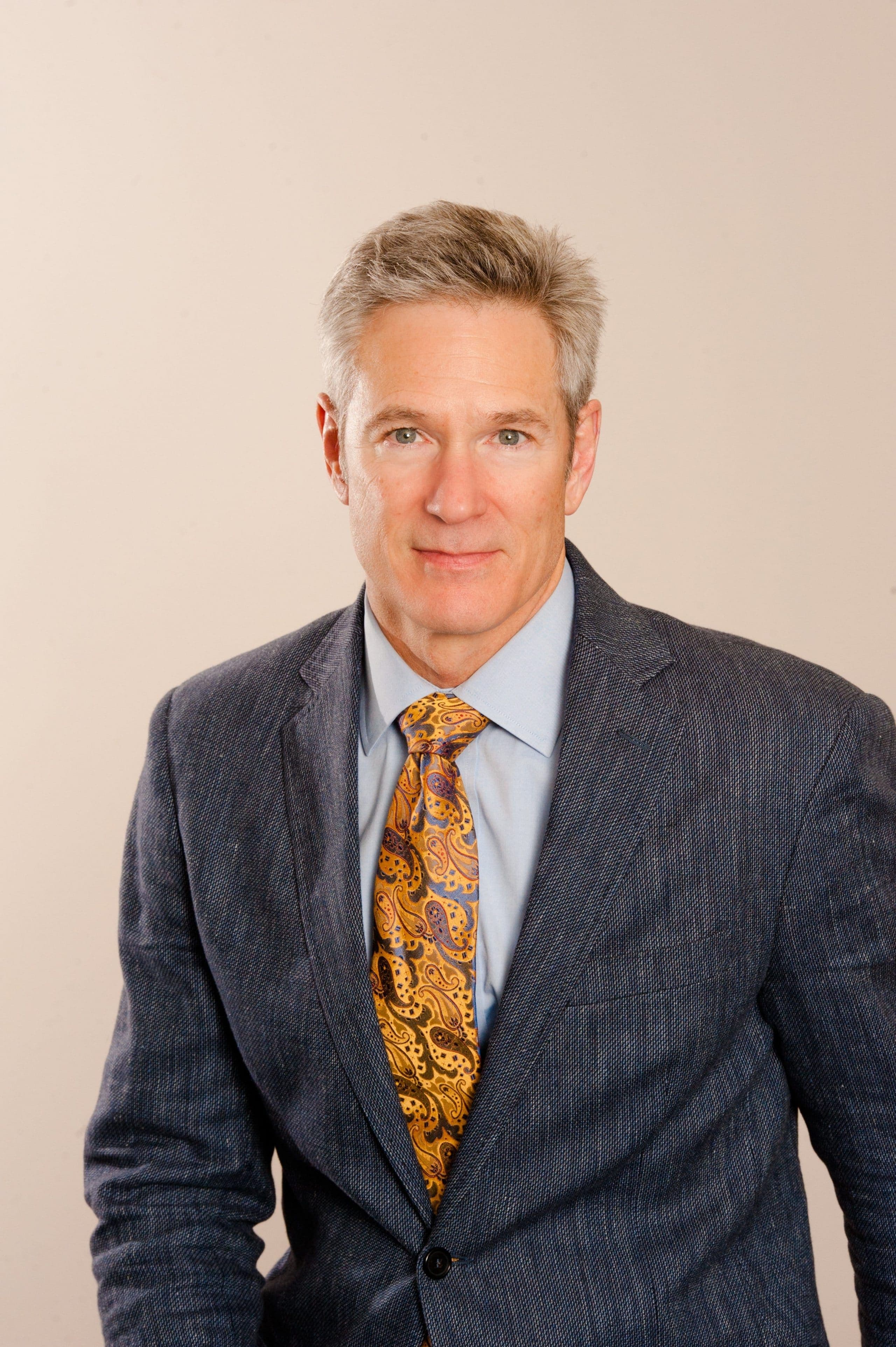 Dr. Richard Grimsley, orthopaedic surgeon, in a dark suit against a neutral background